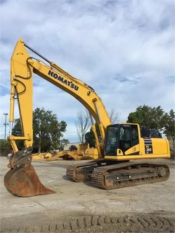 Gul Komatsu PC360LC grävmaskin parkerad utomhus på en grusplan.